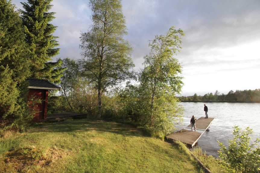 Goodwin plays with his children at the lake behind his property in Växjö