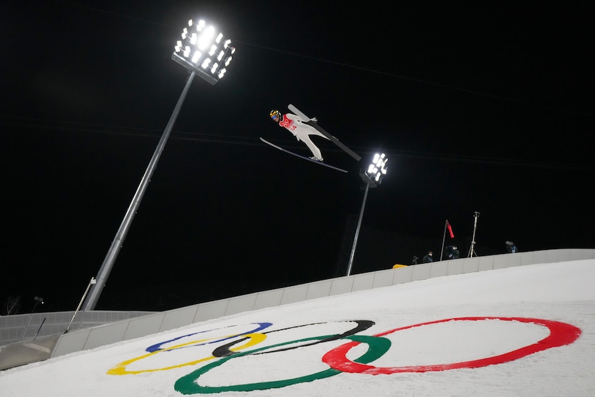 Halvor Egner Granerud, of Norway soars over the Olympic symbol at night in the ski jumping at the Winter Olympics