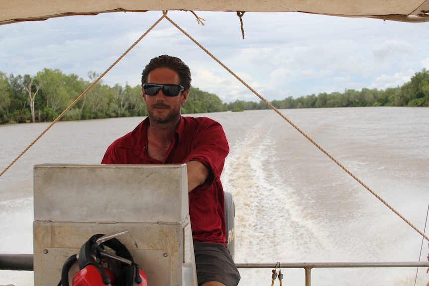 a man driving a boat along a river