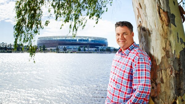 Clint Wheeldon standing next to a tree with Optus Stadium in the background