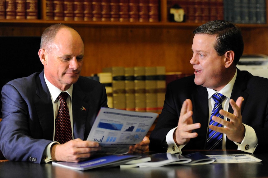 Tim Nicholls (right) and Campbell Newman read through budget papers.