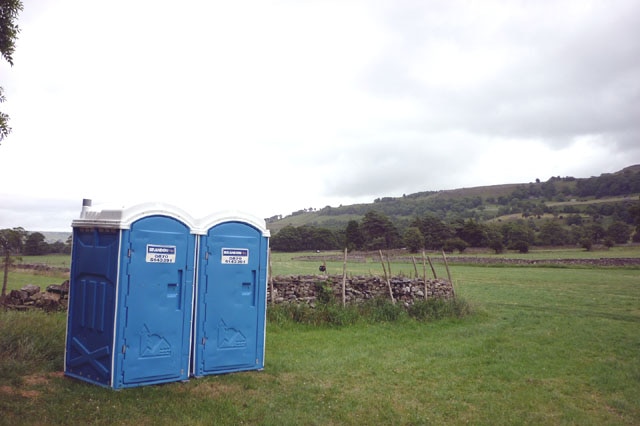 two portable toilets in a field