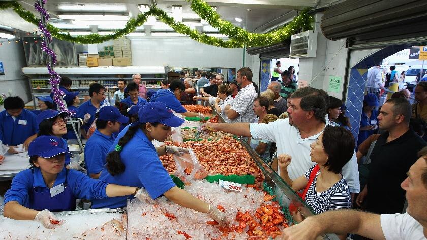 Fishmongers work on stalls as Sydneysiders stock up on their festive seafood supplies