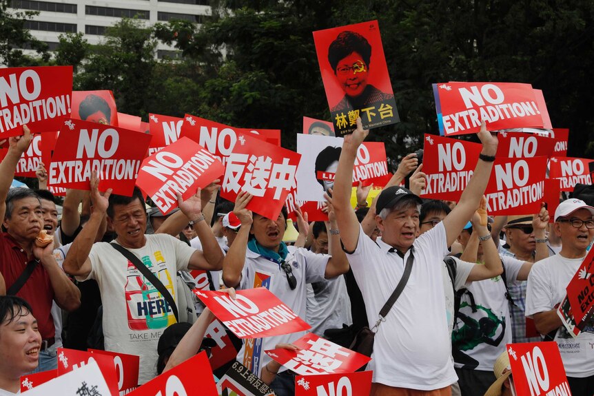 Protesters hold placards during a rally against an extradition law in Hong Kong.