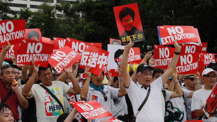 Protesters hold placards during a rally against an extradition law in Hong Kong.