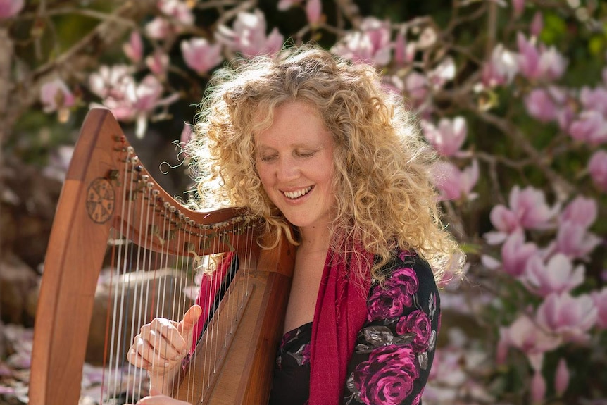 A lady playing the harp.