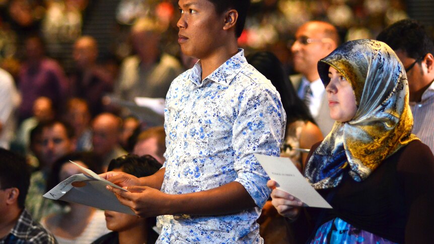 Two new Australians read their oath during the citizenship ceremony