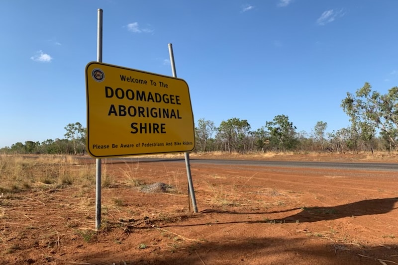A sign saying Doomadgee in an out back setting