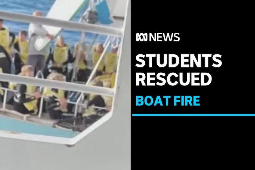 Students Rescued, Boat Fire: A group of people in life jackets on a boat's deck.