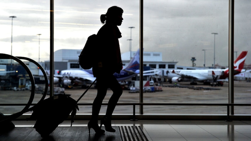 A woman walks through an airport