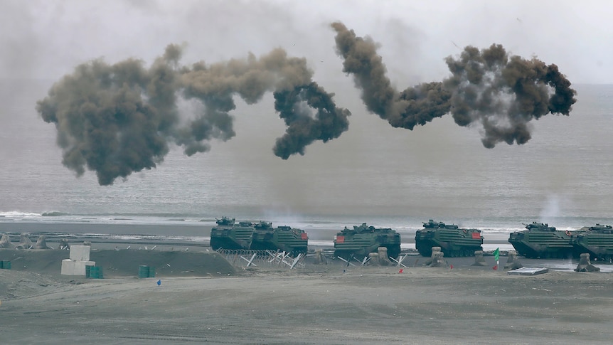 Smoke rises above military vehicles during Taiwan military drills.
