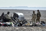 Egyptian army soldiers stand guard next to debris and belongings of passengers of the Kogalymavia airlines plane.