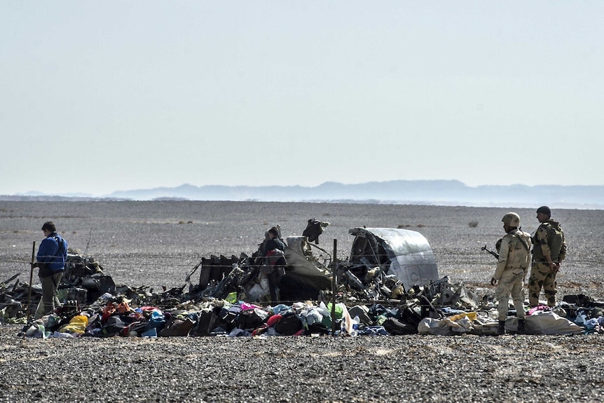 Egyptian army soldiers stand guard next to debris and belongings of passengers of the Kogalymavia airlines plane.