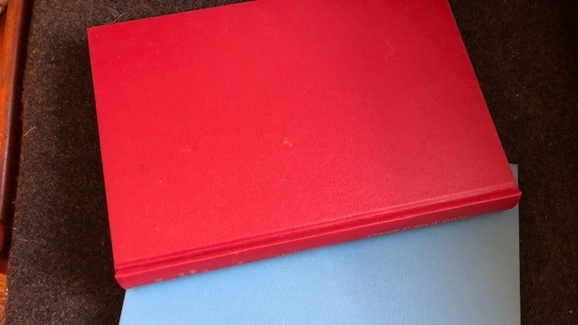 a photo of a red book on top of a blue book.