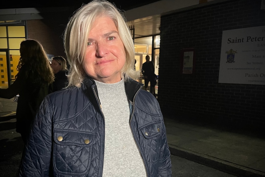 Head and shoulders shot of a woman with grey hair in a blue jacket