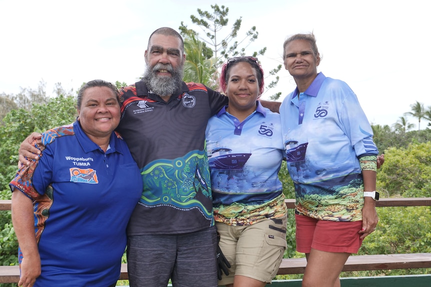 Four people stand and smile at the camera.