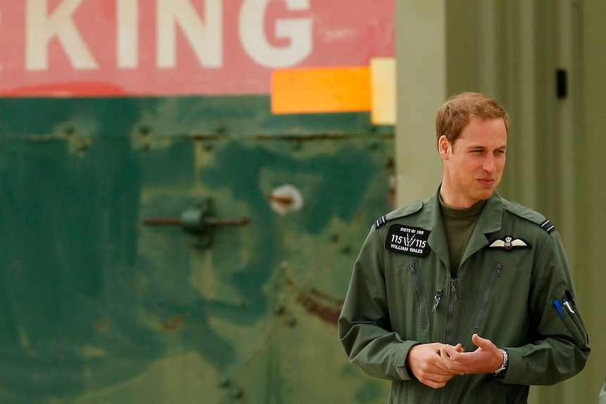 Prince William is wearing a military green jumpsuit.