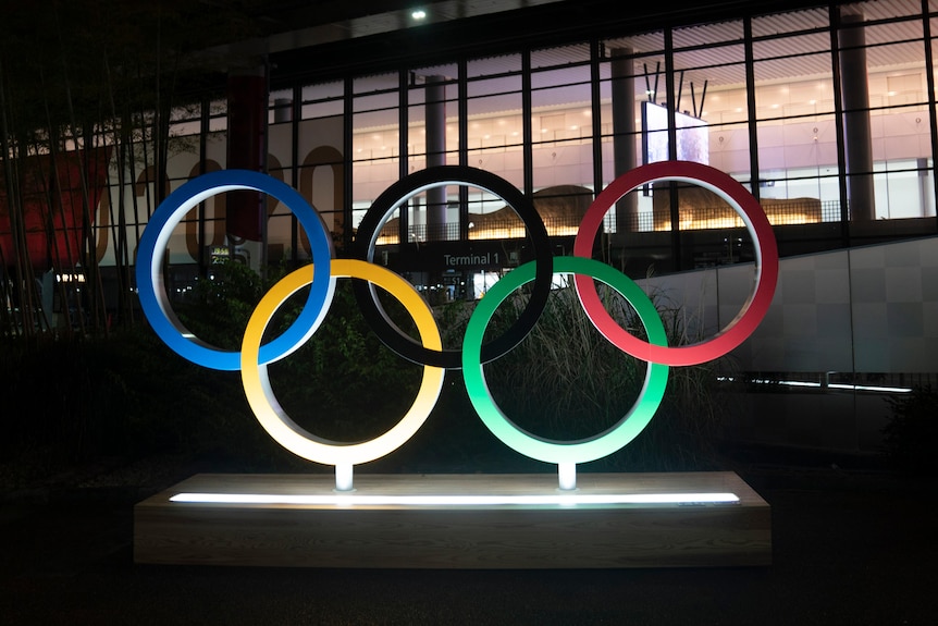 The Olympics sign glowing outside at night for the 2020 Tokyo games