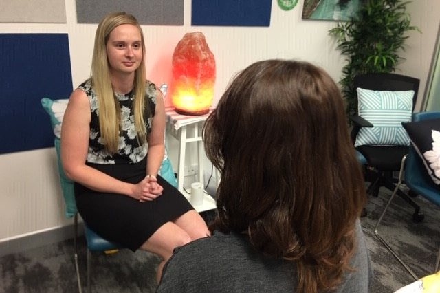 Two women in a comfortable counselling room with a salt lamp.