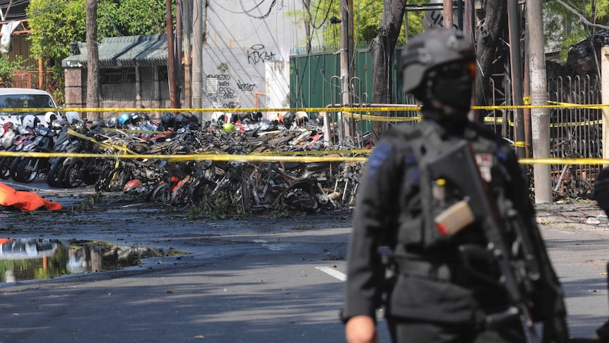 A police officer stands guard near the site where an explosion went off outside a church in Surabaya