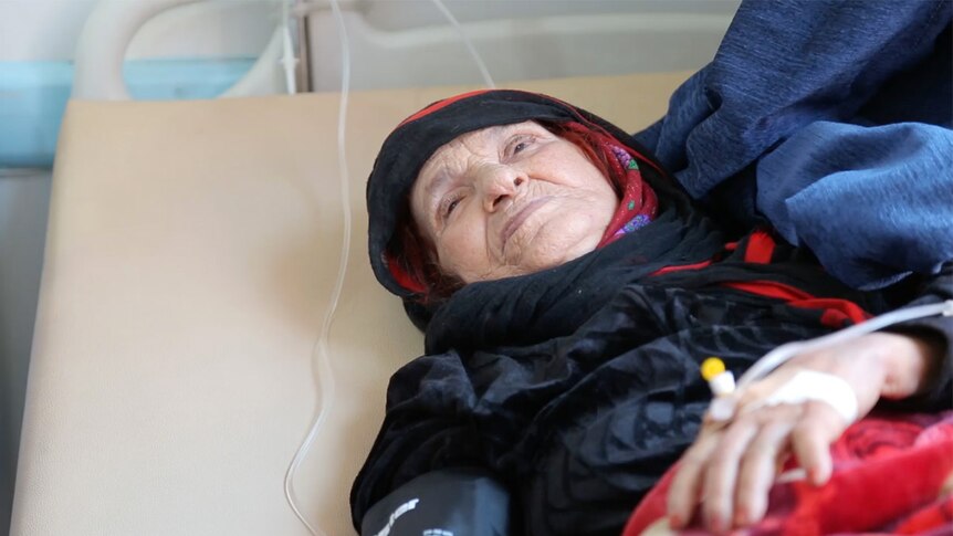 A woman with cholera lies in a hospital bed in Yemen.