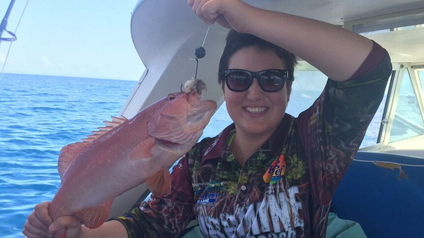 Demi Bettini holds a coral trout caught while fishing off the far north Queensland coast.