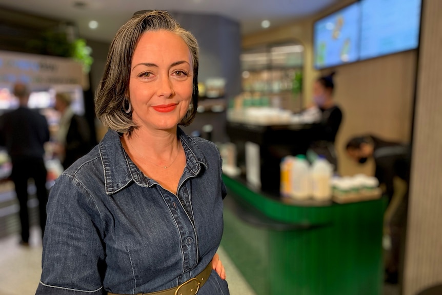 Jackie Middleton stands in front of a green cafe counter.
