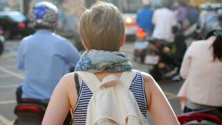 A woman travelling on her own navigates a busy street for ABC Life travel page.