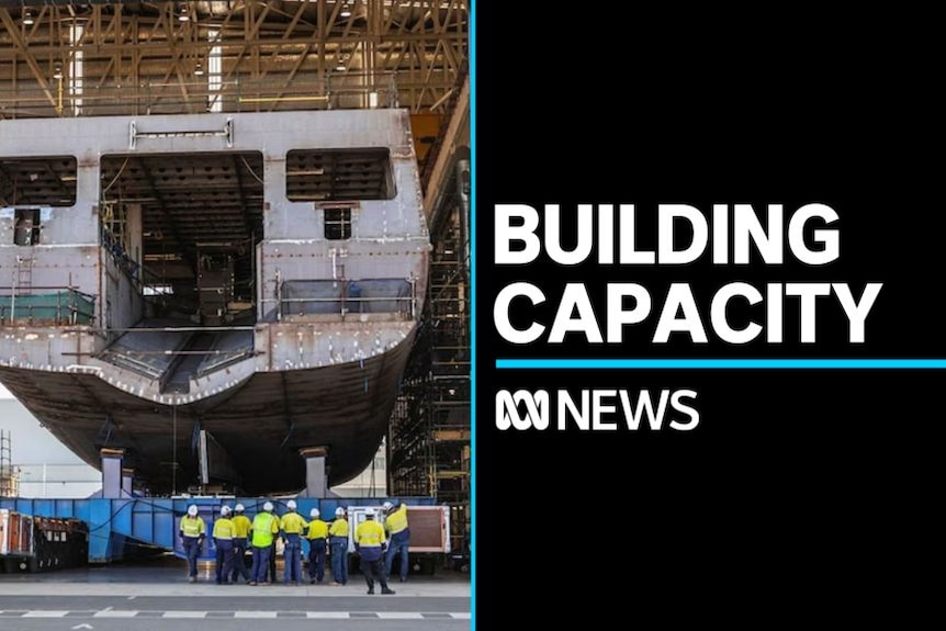 Building Capacity: Hull of a naval ship being built at a shipyard