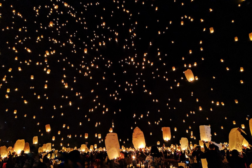 A crowd of people releasing lanterns to the sky