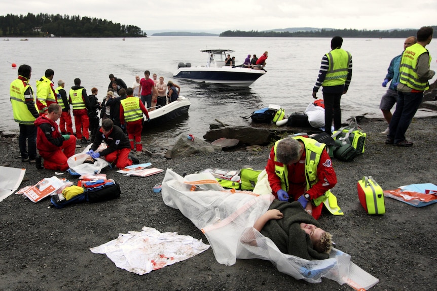 A wounded woman is treated after leaving Utoya island (in the distance)