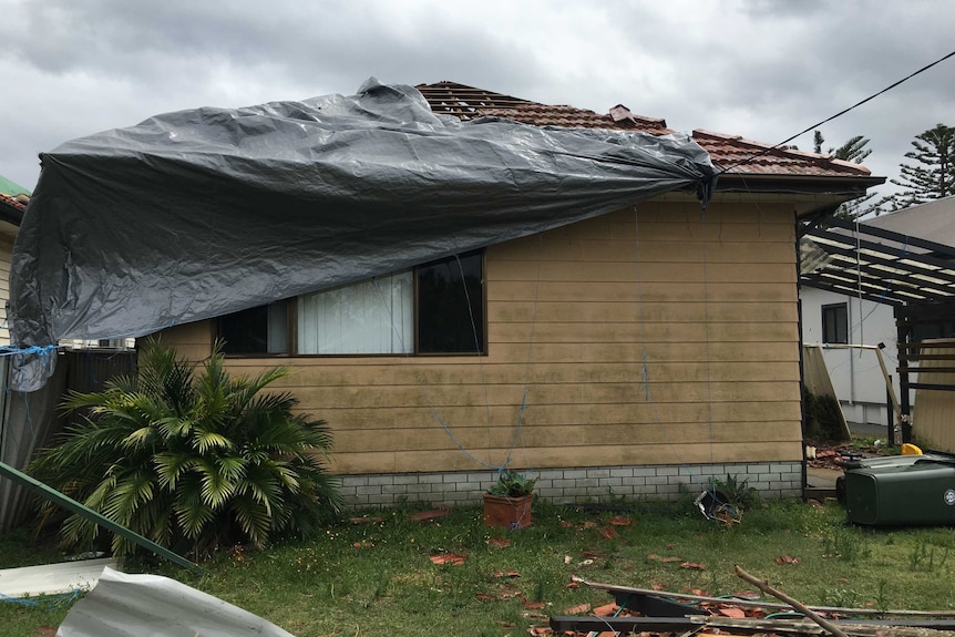 Wild weather rips a tarp off a home.