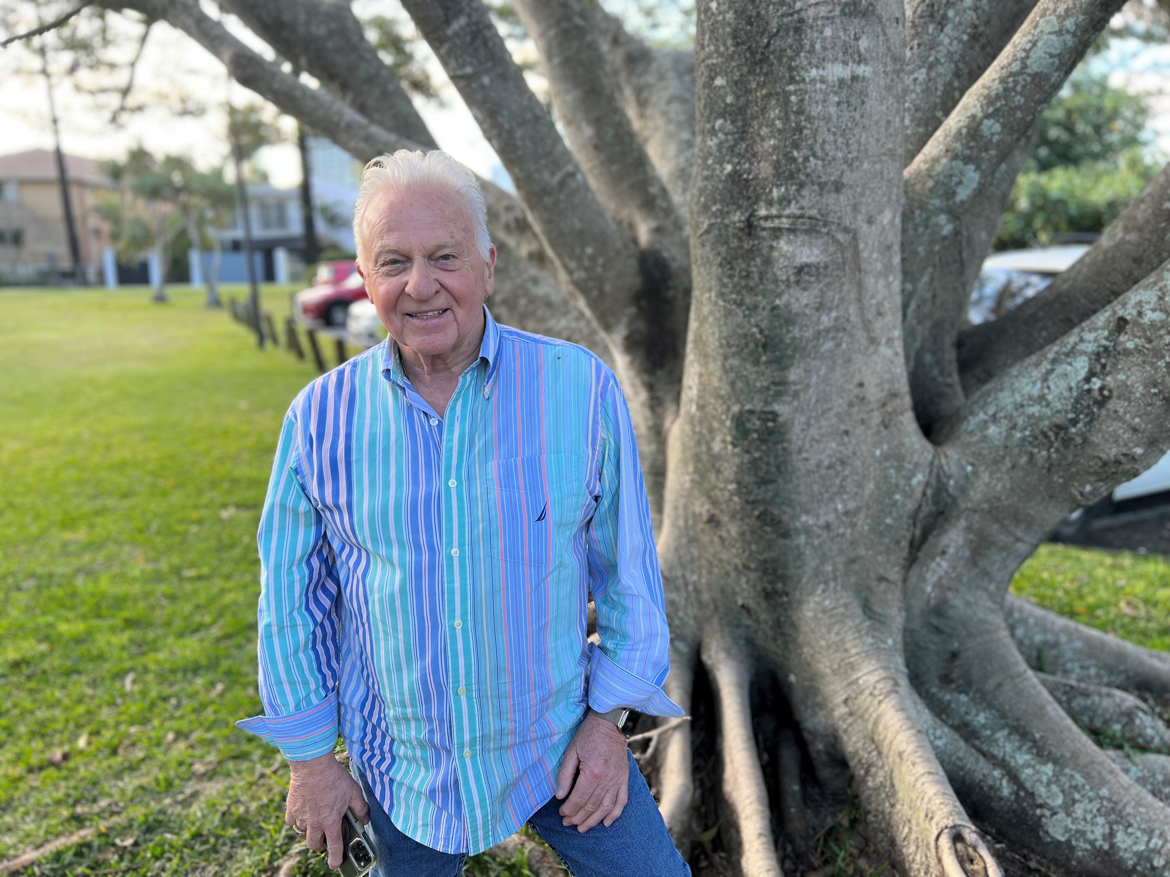 a man with gray hair wearing a blue shirt.