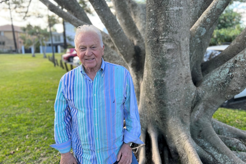 a man with gray hair wearing a blue shirt.