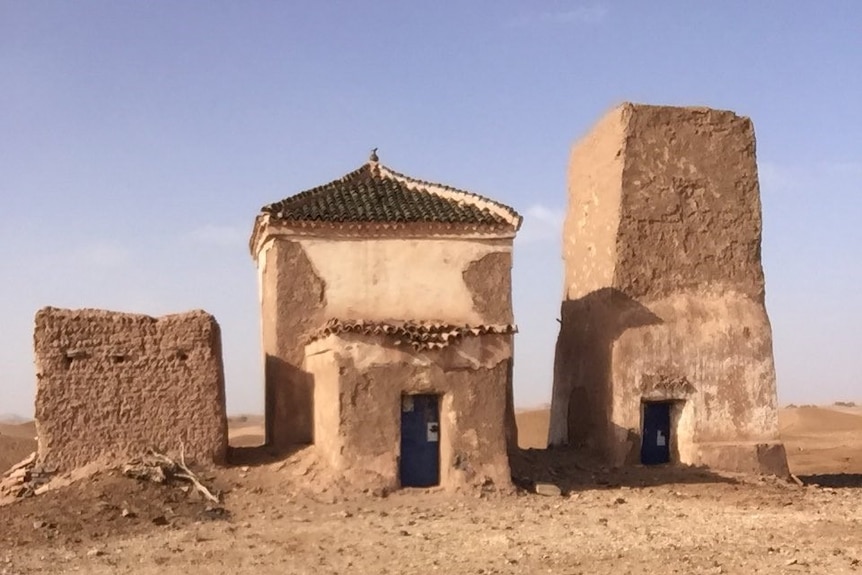 Three small buildings in a desert 