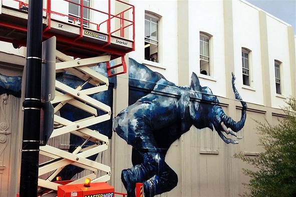 a painting of a large blue elephant on an external wall
