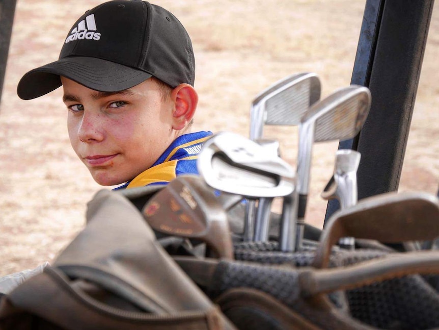 child sitting in golf buggy