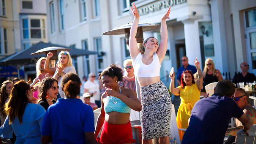 A group of women dancing at an outdoor pub