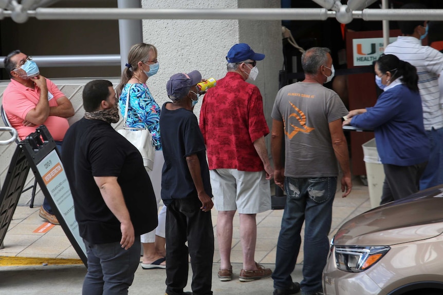 People wait in a queue outside a hospital in Miami, United States.