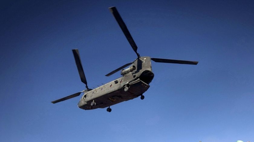 A UH-47 Chinook helicopter lands over US soldiers and Afghan National Army soldiers