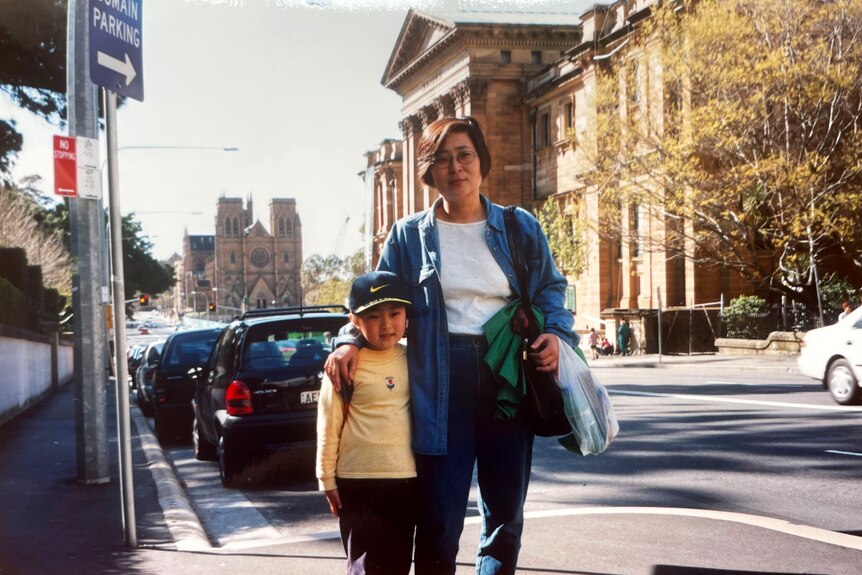 Naeun as a child with her mother on a city street.