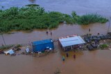 Aerial shot of people in water near a river that has burst its banks in Fiji.