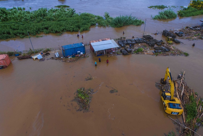 Aerial shot of people in water near a river that has burst its banks in Fiji.