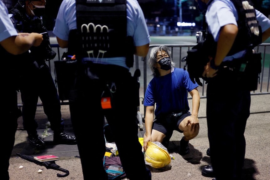 Police officers surround a man at Victoria Park in Hong Kong.