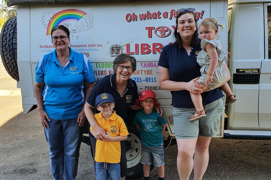 Vicki Olds and Emma Fenton with children in front of the toy library car