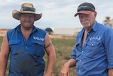 Two fair-skinned male farmers, Kevin and Nathan, in blue work shirts frown on their farm in front of mine site