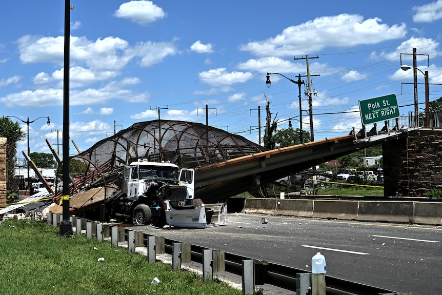 Truck sits crushed under the bridge 