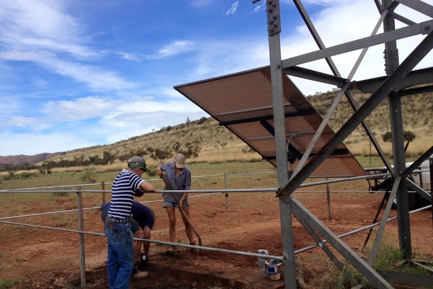 Undoolya station staff put up solar panels at a rare mono windmill
