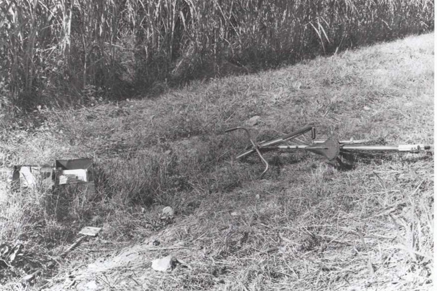 A discarded bike and school bag in bushland