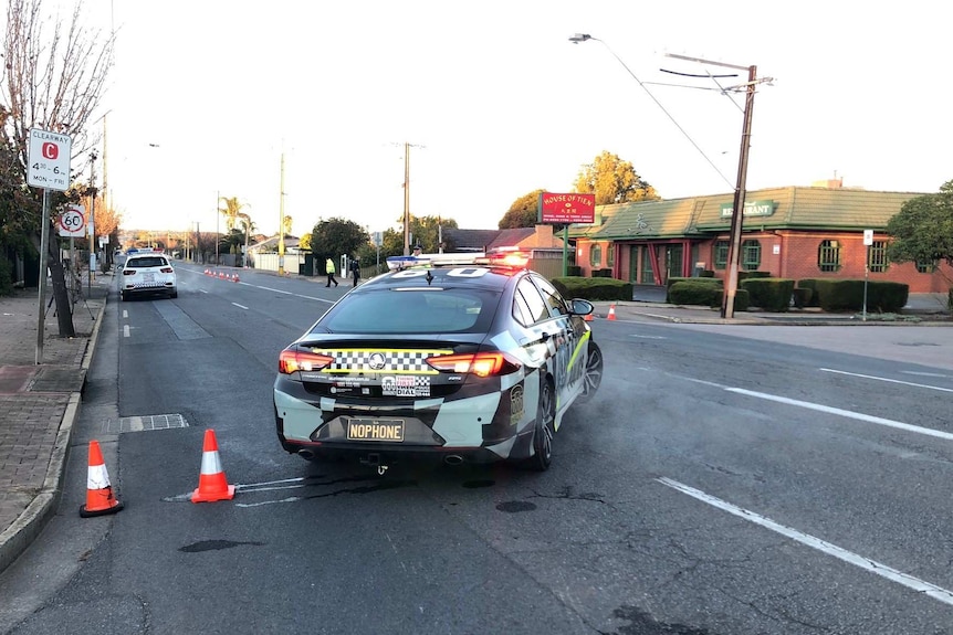 A police car blocking a road in front of a Chinese restaurant